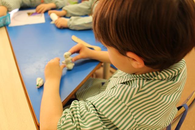 Il bambino scolpisce i mestieri dall'impasto al sale.